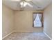 Bright bedroom with ceiling fan and a window with neutral walls and carpet floors at 609 Grand Ashbury Ln, Buford, GA 30518