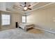 Spacious bedroom featuring a tray ceiling, ceiling fan, and natural light at 609 Grand Ashbury Ln, Buford, GA 30518