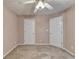 Cozy bedroom with neutral carpet, ceiling fan, and two entry doors and closet doors at 609 Grand Ashbury Ln, Buford, GA 30518