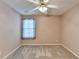 A serene bedroom with neutral walls and carpet flooring and a ceiling fan at 609 Grand Ashbury Ln, Buford, GA 30518
