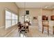 Bright dining area features an elegant light fixture, light-colored floors, and many windows for natural light at 609 Grand Ashbury Ln, Buford, GA 30518
