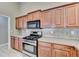 Kitchen featuring stainless appliances, wood cabinets, and tile backsplash at 609 Grand Ashbury Ln, Buford, GA 30518