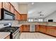 Modern kitchen features stainless steel appliances, wood cabinetry, and spacious countertops at 609 Grand Ashbury Ln, Buford, GA 30518