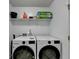 Functional laundry area with washer, dryer, storage shelving and neutral walls at 609 Grand Ashbury Ln, Buford, GA 30518