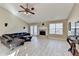 Spacious living room with vaulted ceiling, fireplace, dark leather seating and light-colored flooring at 609 Grand Ashbury Ln, Buford, GA 30518