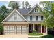 Charming two-story home with a two-car garage, stone accents, and well-maintained landscaping and a red front door at 93 Richmond Way, Villa Rica, GA 30180