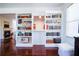 Bright living room featuring hardwood floors, built-in bookshelves, and a view of the fireplace in another room at 93 Richmond Way, Villa Rica, GA 30180