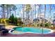 Inviting backyard pool with brick surround, surrounded by trees, offering a private and relaxing outdoor space at 93 Richmond Way, Villa Rica, GA 30180