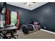 Cozy bedroom with dark blue walls, a comfortable bed, a desk, and a window offering natural light at 154 Carmen Ln, Dallas, GA 30157