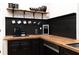 Stylish kitchen with dark cabinets, butcher block countertops, and open shelving for storage at 154 Carmen Ln, Dallas, GA 30157