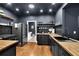 Spacious kitchen with black cabinets, wood countertops, stainless steel appliances, and wood floors at 154 Carmen Ln, Dallas, GA 30157