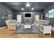 Cozy living room with dark grey walls, wood floors, stone fireplace, and comfortable seating at 154 Carmen Ln, Dallas, GA 30157