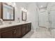 Bathroom with double sink, wooden cabinets, and a glass door shower at 3210 Steinbeck St, Cumming, GA 30041