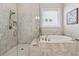 Bathroom featuring a separate shower and tub with tile surround at 3210 Steinbeck St, Cumming, GA 30041