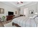 Primary bedroom with hardwood floors, ceiling fan, and a TV at 3210 Steinbeck St, Cumming, GA 30041