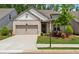 Charming single-story home featuring a brick facade, well-manicured lawn, and an attached two-car garage at 3210 Steinbeck St, Cumming, GA 30041