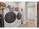 A functional laundry room featuring a modern washer and dryer and practical shelving at 3210 Steinbeck St, Cumming, GA 30041