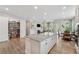 Open-concept living space with a large kitchen island, pantry, fireplace, and cozy living room at 3210 Steinbeck St, Cumming, GA 30041