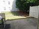 View of fenced backyard with a concrete patio, grassy area and mature landscaping at 3216 Panthers Trce, Decatur, GA 30034