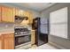 Efficient kitchen features wooden cabinets, stainless steel stove, and black refrigerator, maximizing space at 3216 Panthers Trce, Decatur, GA 30034
