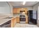 Kitchen boasts wooden cabinets, black appliances and a gas range oven at 3216 Panthers Trce, Decatur, GA 30034