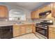 Kitchen showcases wooden cabinetry, gas range, and black appliances at 3216 Panthers Trce, Decatur, GA 30034