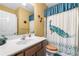 Bathroom with a white sink, wood cabinets, and a white shower curtain with a peacock design at 5015 Scuppernong Ct, Austell, GA 30106