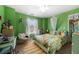 Bright bedroom with green walls, a unique swing chair, and a jungle themed bedspread at 5015 Scuppernong Ct, Austell, GA 30106