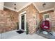 Inviting covered front porch with brick accents, hanging lights, and cozy seating area at 5015 Scuppernong Ct, Austell, GA 30106