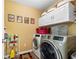 Bright laundry room with modern front-load washer and dryer, and white storage cabinets at 5015 Scuppernong Ct, Austell, GA 30106