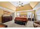 Large primary bedroom with a tray ceiling, soft carpet, and elegant furniture at 5015 Scuppernong Ct, Austell, GA 30106
