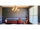 Elegant dining room with dark walls, white trim, a traditional chandelier, and a wooden dining table at 7491 Hilltop Way, Atlanta, GA 30349