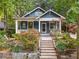 Charming blue house with a lovely front yard, wooden steps, and lush greenery all around at 165 Hale Ne St, Atlanta, GA 30307