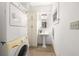 Bright laundry room includes stacked washer/dryer, vanity sink, tiled floor, and window at 165 Hale Ne St, Atlanta, GA 30307