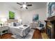 Main bedroom with hardwood floors, ceiling fan, fireplace, and a decorative area rug at 165 Hale Ne St, Atlanta, GA 30307