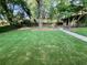 Lush green backyard with mature trees and a charming shed at the end of a paved pathway at 3133 Rebecca St, Covington, GA 30014