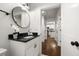 Bright bathroom boasts a black granite countertop, round mirror, and white cabinets at 540 Atwood Sw St, Atlanta, GA 30310