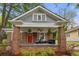 Inviting brick front porch with ample seating, stylish decor, and a vibrant red door at 540 Atwood Sw St, Atlanta, GA 30310