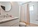 Modern bathroom with a marble countertop vanity, tub, and striped shower curtain at 797 Greenwood Ne Ave, Atlanta, GA 30306