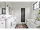 Bright bathroom featuring double sinks, a soaking tub, and modern fixtures at 797 Greenwood Ne Ave, Atlanta, GA 30306