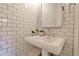 Elegant powder room featuring a pedestal sink, subway tiles, and stylish accents at 797 Greenwood Ne Ave, Atlanta, GA 30306