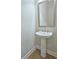 Elegant half-bathroom featuring a pedestal sink, modern fixtures, and a decorative mirror at 2128 Sonoma Se Dr, Smyrna, GA 30080