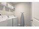 Convenient laundry room with washer, dryer, overhead shelving, and ironing board at 3401 Endurance Ct # 10, Atlanta, GA 30349