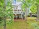 Exterior shot of the house with a large deck, spiral staircase, and lush landscaping at 3722 Somerset Nw Rdg, Kennesaw, GA 30144