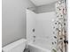 Clean bathroom showcases white tile, tub with shower, and fun dinosaur shower curtain at 3722 Somerset Nw Rdg, Kennesaw, GA 30144