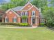 Charming two-story red brick home boasts a manicured lawn and lush landscaping at 3722 Somerset Nw Rdg, Kennesaw, GA 30144