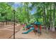 A playground with slides, swings, and a climbing structure, set in a wooded area with walking paths at 3722 Somerset Nw Rdg, Kennesaw, GA 30144