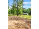 View of the yard of the home, with tall trees and a dirt driveway leading up to the house at 415 Gray Rd, Carrollton, GA 30116
