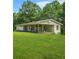 A view of the rear of a home with a sprawling green lawn and mature trees at 415 Gray Rd, Carrollton, GA 30116