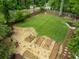 Aerial view of a spacious backyard with gravel beds, planting boxes and a large grassy area at 1657 Millhouse Lndg, Marietta, GA 30066